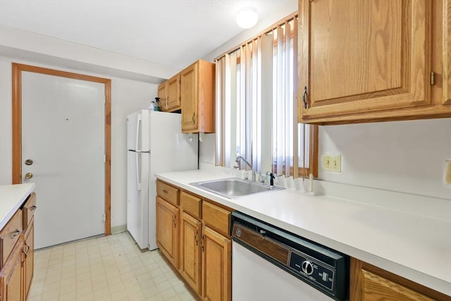 kitchen featuring light countertops, white appliances, a sink, and a healthy amount of sunlight