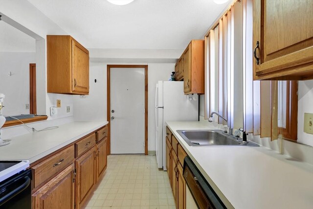 kitchen featuring electric range, a sink, light countertops, dishwasher, and light floors