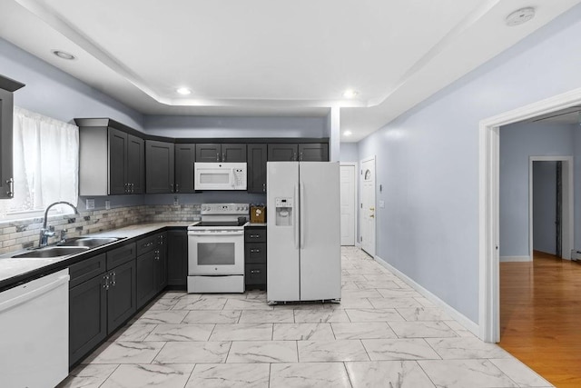 kitchen featuring recessed lighting, white appliances, a sink, baseboards, and marble finish floor