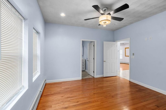 unfurnished bedroom with a ceiling fan, a baseboard radiator, light wood-style flooring, and baseboards