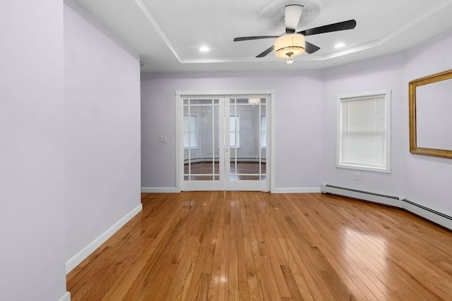 empty room with baseboards, a raised ceiling, a ceiling fan, light wood-style floors, and recessed lighting