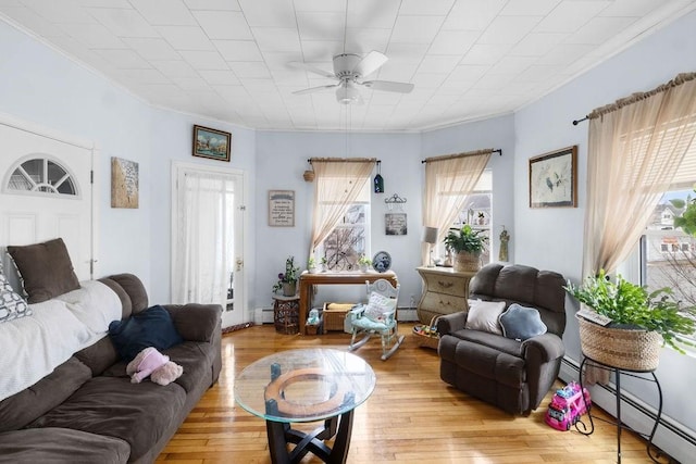 living room with a baseboard radiator, light wood-style flooring, baseboard heating, and a ceiling fan