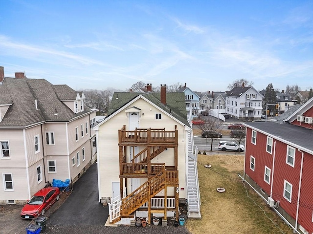 exterior space featuring stairs, aphalt driveway, and a residential view