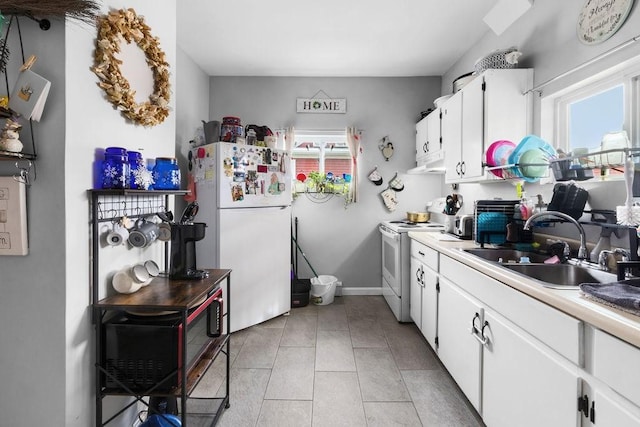 kitchen featuring a wealth of natural light, white appliances, a sink, and under cabinet range hood