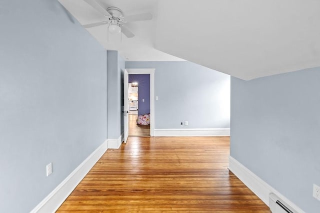 additional living space featuring ceiling fan, a baseboard radiator, wood finished floors, and baseboards