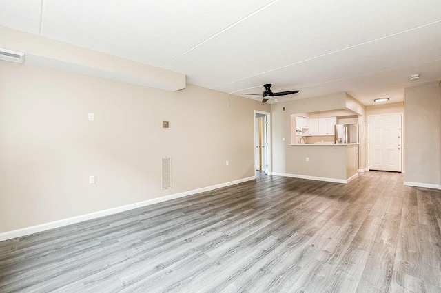 4975 Washington St Unit 313, Boston, MA 02132 - unfurnished living room with ceiling fan, light wood-style floors, and baseboards