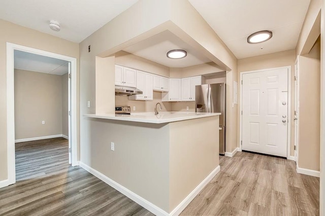 4975 Washington St Unit 313, Boston, MA 02132 - kitchen with stainless steel fridge with ice dispenser, light wood finished floors, range, under cabinet range hood, and white cabinetry