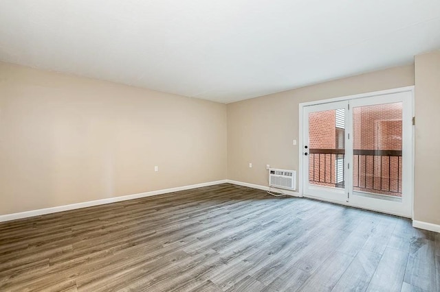 4975 Washington St Unit 313, Boston, MA 02132 - spare room with wood finished floors, baseboards, and a wall mounted air conditioner