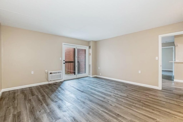 4975 Washington St Unit 313, Boston, MA 02132 - unfurnished room featuring wood finished floors, an AC wall unit, and baseboards
