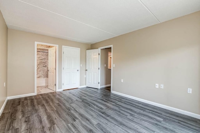 4975 Washington St Unit 313, Boston, MA 02132 - unfurnished bedroom featuring baseboards, wood finished floors, and ensuite bathroom