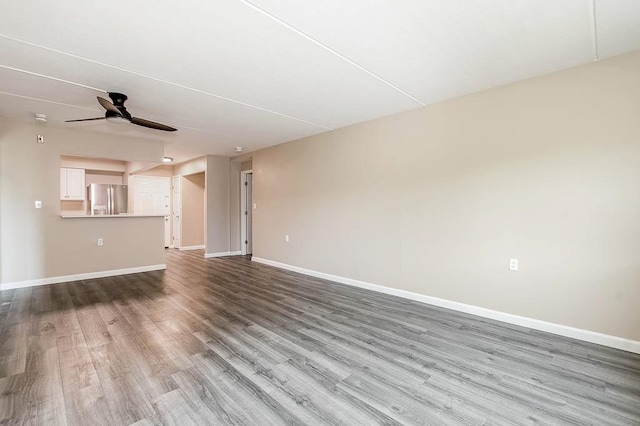 4975 Washington St Unit 313, Boston, MA 02132 - unfurnished living room with ceiling fan, wood finished floors, and baseboards