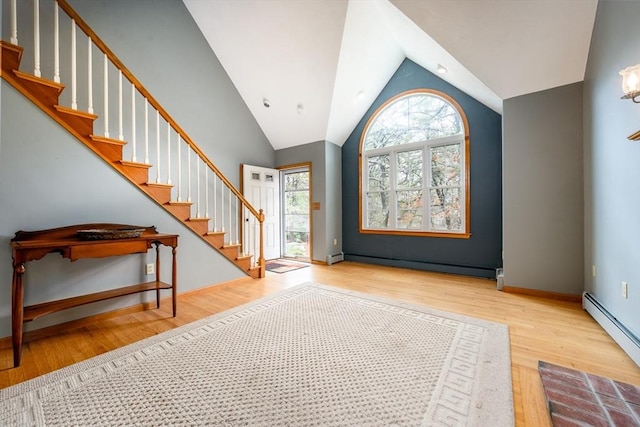 foyer featuring stairway, wood finished floors, baseboard heating, baseboards, and a baseboard heating unit