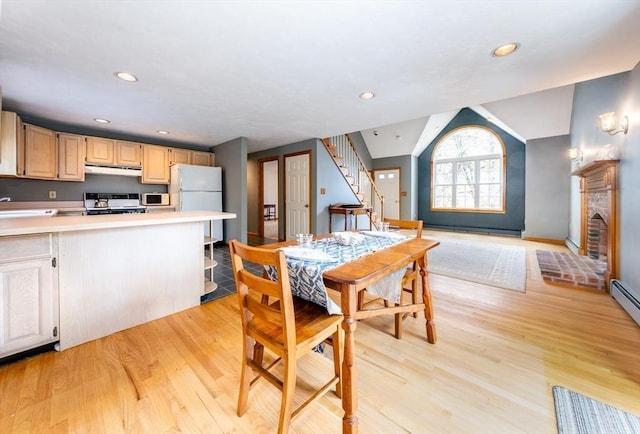 dining room with lofted ceiling, stairs, recessed lighting, and light wood finished floors