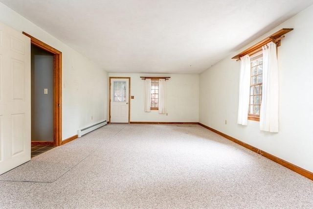 empty room featuring baseboards, a baseboard heating unit, and light colored carpet