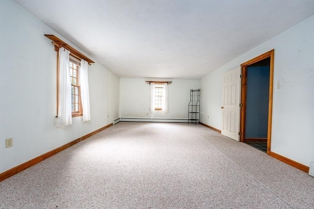 empty room with baseboards, baseboard heating, and carpet floors