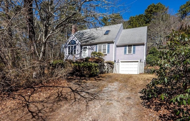 new england style home with dirt driveway, a garage, and a chimney