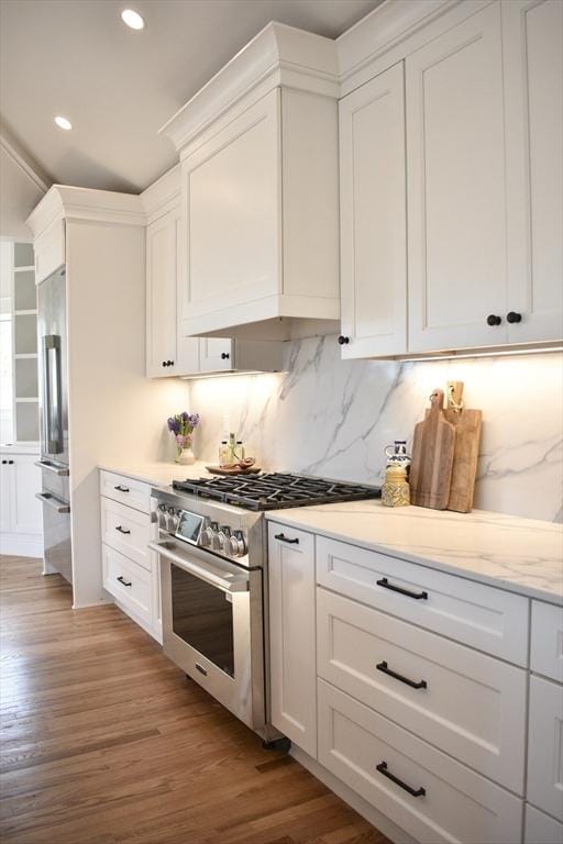 kitchen with high end appliances, light wood-type flooring, and white cabinets