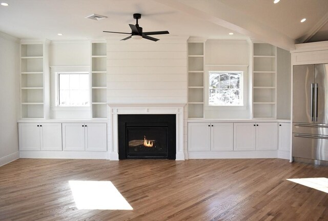 unfurnished living room with plenty of natural light, ceiling fan, and light wood-type flooring