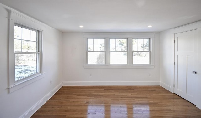 unfurnished room featuring a healthy amount of sunlight and hardwood / wood-style floors