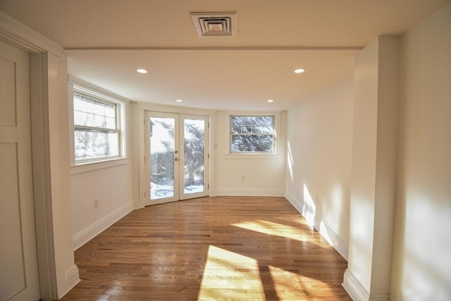 spare room with hardwood / wood-style flooring and french doors