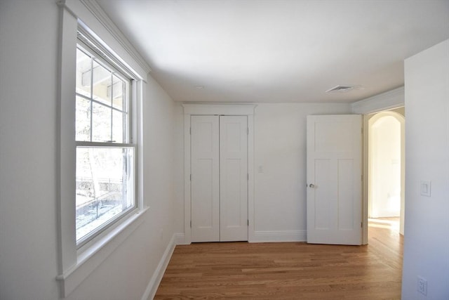 unfurnished bedroom featuring wood-type flooring and a closet