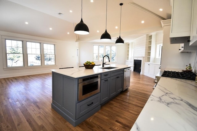 kitchen with a large island, sink, gray cabinets, appliances with stainless steel finishes, and white cabinets