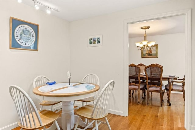 54 Mcnamara Ave, Yarmouth, MA 02673 - dining space with light wood finished floors, a chandelier, baseboards, and rail lighting
