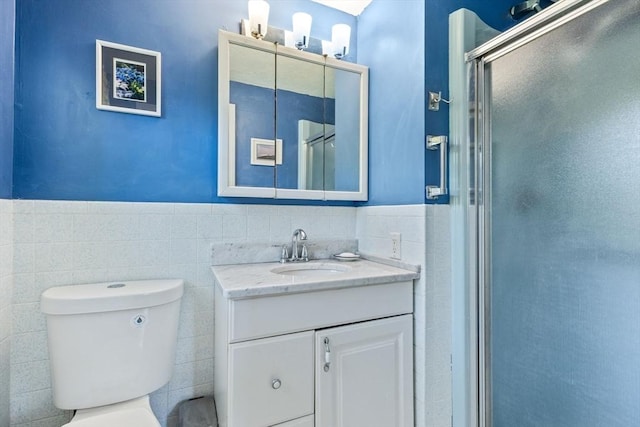 54 Mcnamara Ave, Yarmouth, MA 02673 - bathroom featuring tile walls, vanity, toilet, a stall shower, and wainscoting