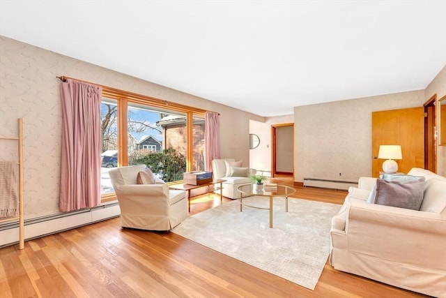 living area featuring wallpapered walls, a baseboard heating unit, and wood finished floors