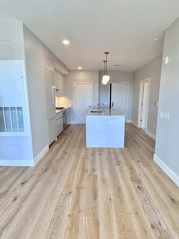 191 Washington St Unit 708, Boston, MA 02135 - kitchen featuring pendant lighting, light wood-type flooring, light countertops, baseboards, and recessed lighting
