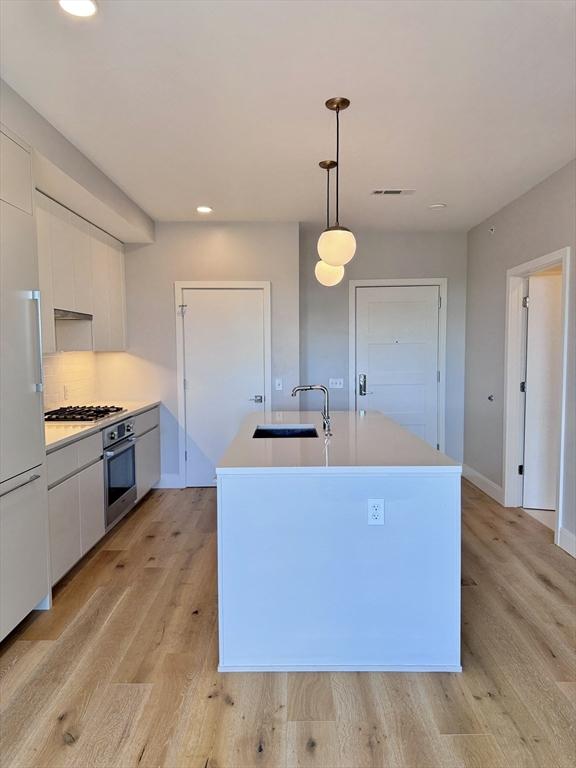 191 Washington St Unit 708, Boston, MA 02135 - kitchen with a sink, appliances with stainless steel finishes, modern cabinets, white cabinetry, and recessed lighting
