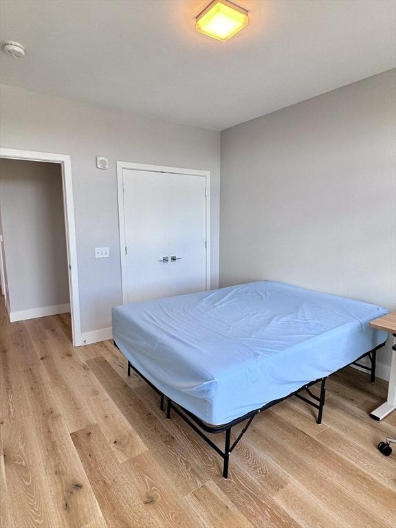 191 Washington St Unit 708, Boston, MA 02135 - bedroom featuring light wood-style floors, baseboards, and a closet