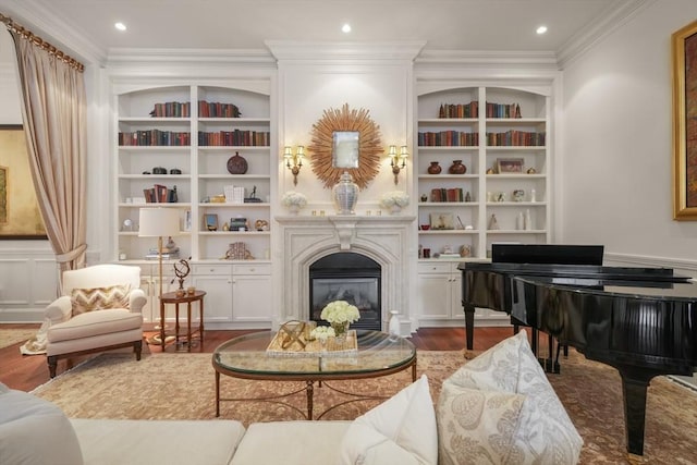 living area with built in shelves, a glass covered fireplace, wood finished floors, recessed lighting, and crown molding