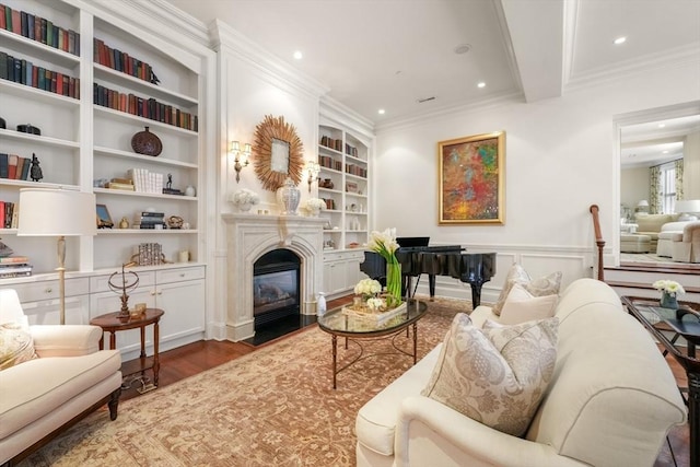 living area with a fireplace with flush hearth, built in features, wood finished floors, recessed lighting, and crown molding