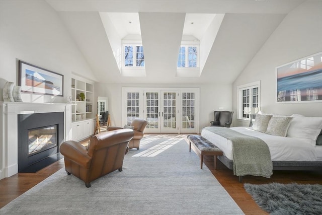 bedroom with dark hardwood / wood-style flooring, access to outside, high vaulted ceiling, and french doors