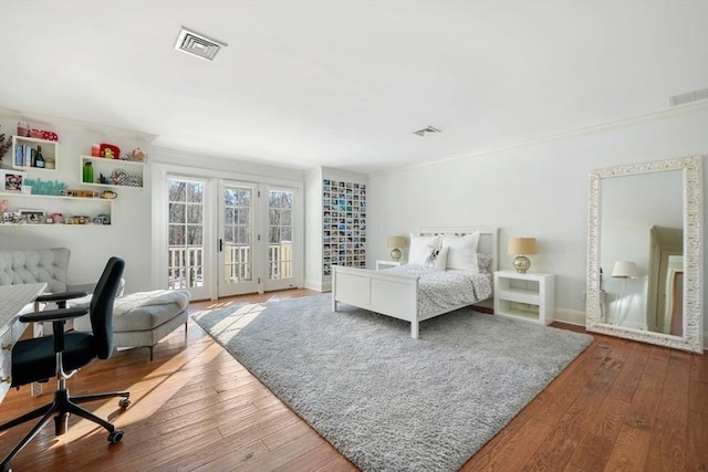 bedroom featuring hardwood / wood-style flooring, ornamental molding, and access to outside