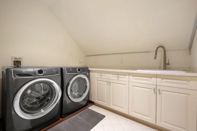 washroom with cabinets, washing machine and dryer, and sink