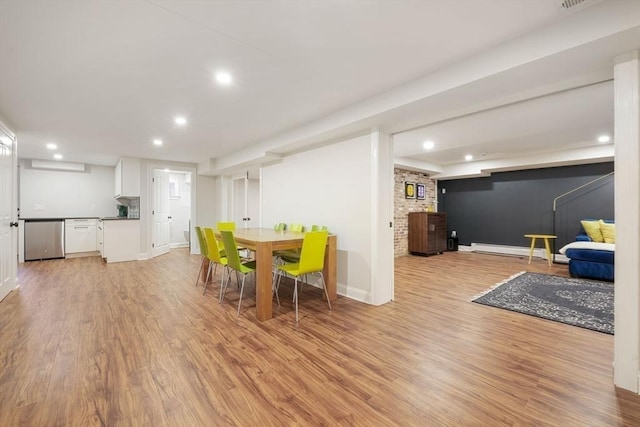 dining space with a baseboard heating unit and light hardwood / wood-style flooring