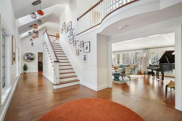 entryway featuring a towering ceiling and wood-type flooring