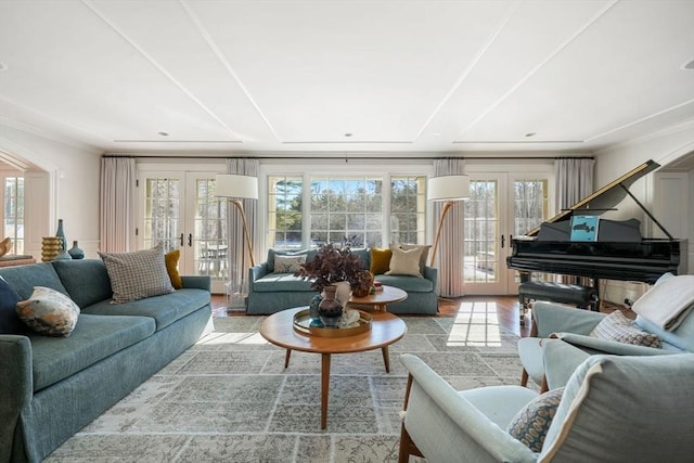 living room with ornamental molding, french doors, and light wood-type flooring