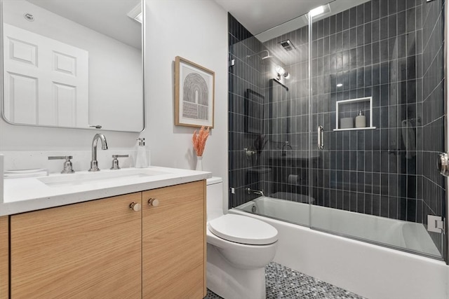 full bathroom featuring enclosed tub / shower combo, vanity, tile patterned floors, and toilet