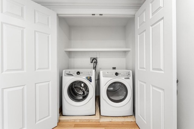 washroom featuring hardwood / wood-style floors and washing machine and clothes dryer