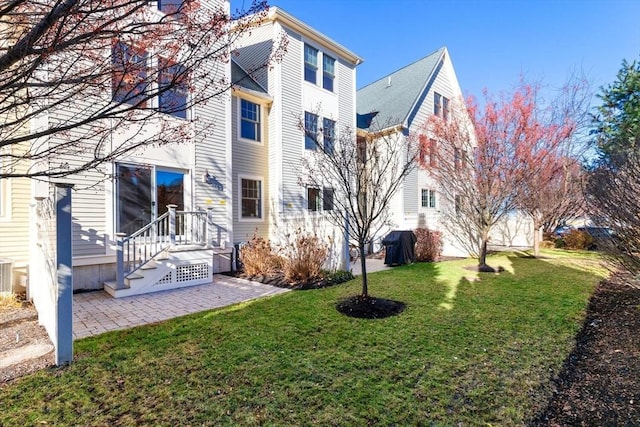 rear view of house featuring a patio, a yard, and central AC unit