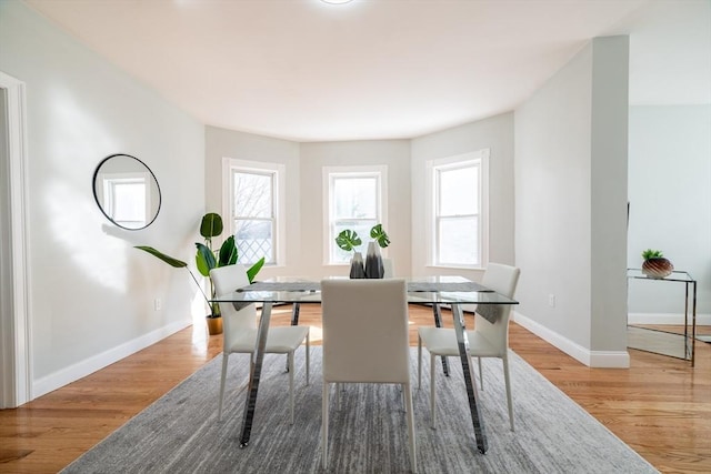 dining room with plenty of natural light, baseboards, and wood finished floors