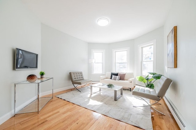 living room featuring baseboards, baseboard heating, and wood finished floors