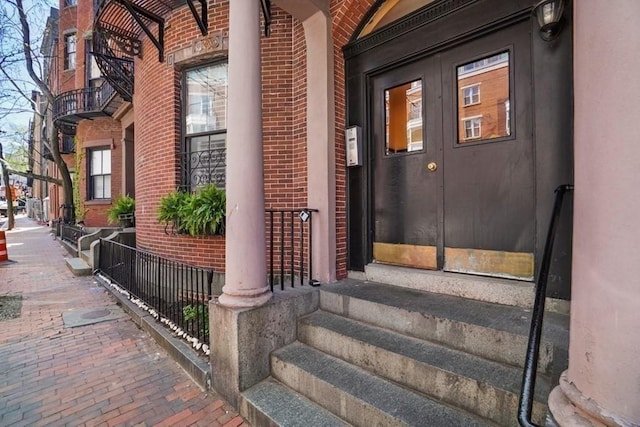 view of exterior entry featuring brick siding