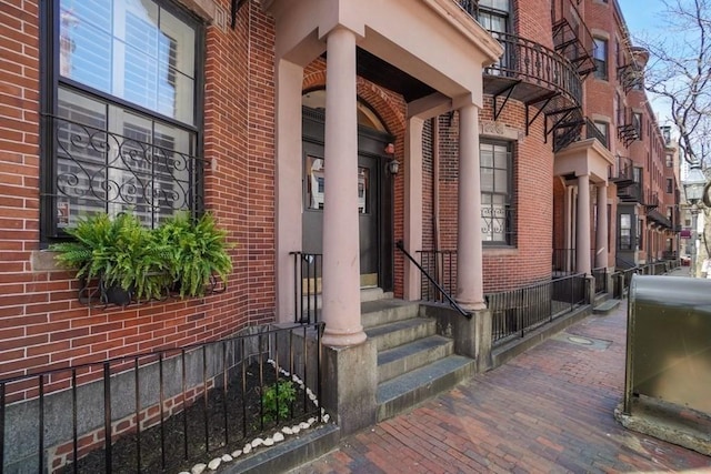 doorway to property featuring brick siding