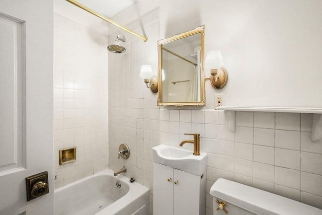 bathroom featuring toilet, shower / tub combination, tile walls, and vanity