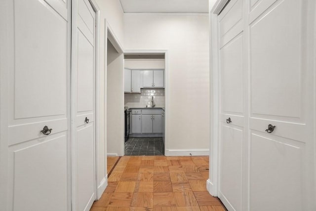 corridor with a sink and baseboards