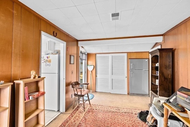 interior space featuring wood walls and light tile patterned floors